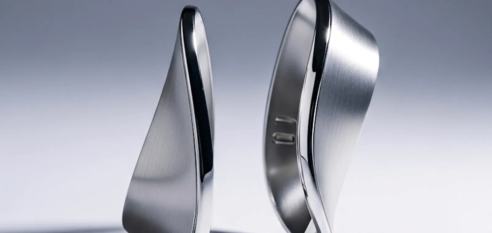 Pair of sleek, modern stainless steel rings with a brushed finish and smooth curved design.